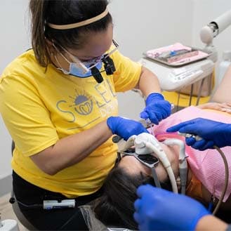 A clinician in a yellow Soleil shirt treating a patient