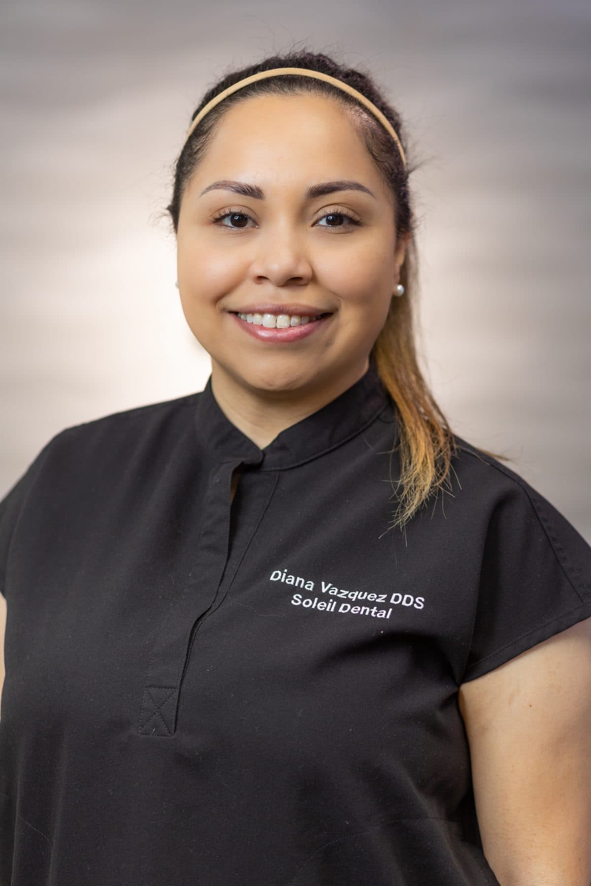 Dr. Diana Vazquez smiling in her black Soleil scrubs