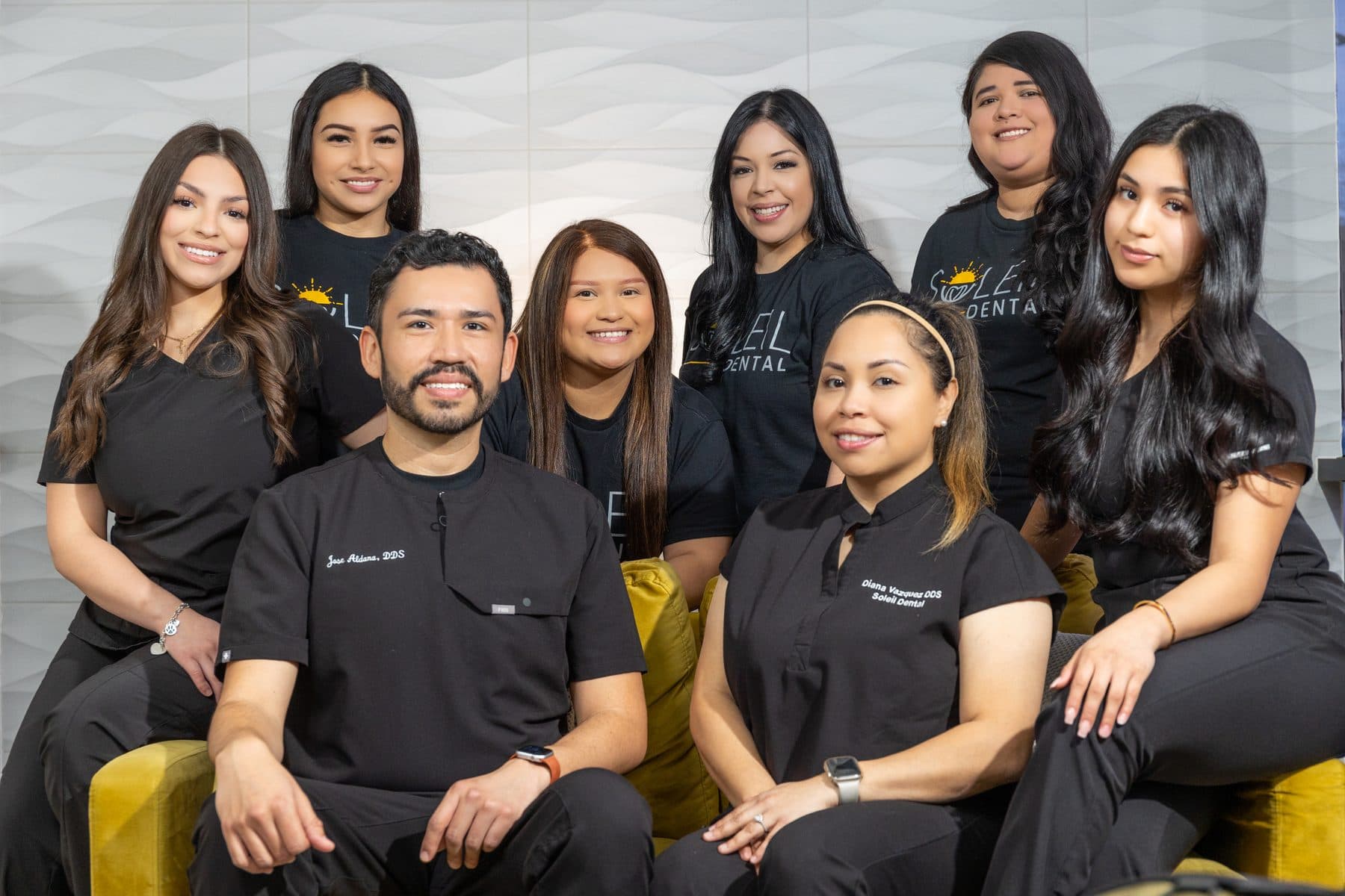 El equipo de Soleil Dental junto en el sillón amarillo de la oficina de Oak Lawn