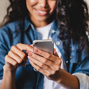 Smiling woman looking at phone at home