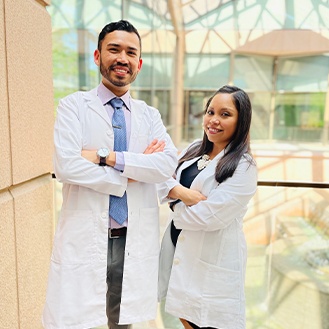 Two dentists smiling with arms folded