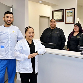 Dental team smiling at front desk