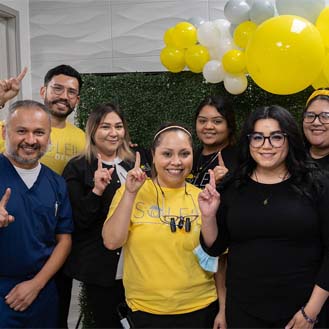 Dental team with balloons smiling