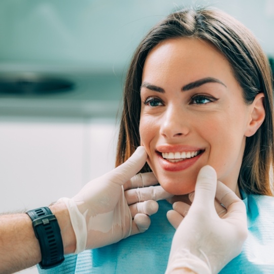 Dentist examining woman's smile after cosmetic dentistry