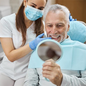 Man looking at smile in handheld mirror