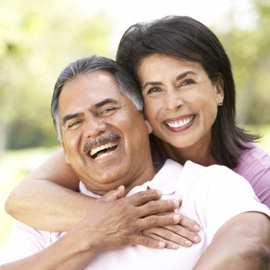 Smiling couple with dental implants in Dallas outside