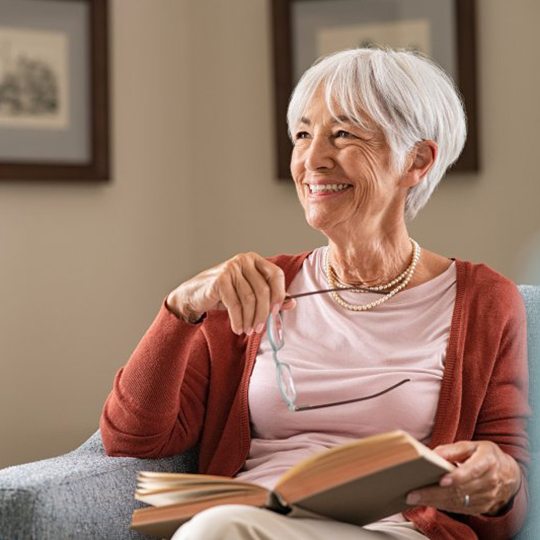 Woman relaxing with a book after getting dental implants