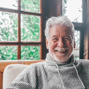 Man smiling in a well-lit room of his house