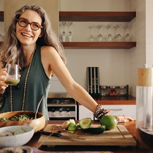 Woman enjoying a vegetable smoothie in her kitchen