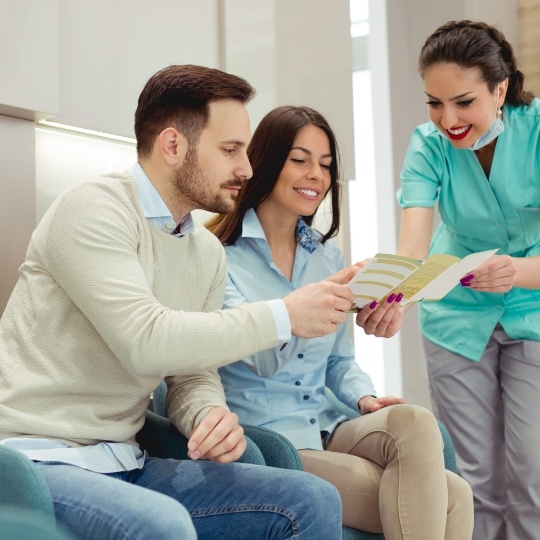 Dental team members and patients reviewing dental insurance coverage