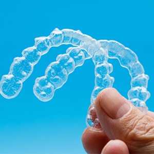 closeup of person holding two clear aligners 