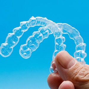 closeup of person holding two clear aligners