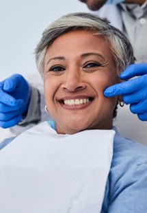 : a patient smiling after getting dental implants near Uptown