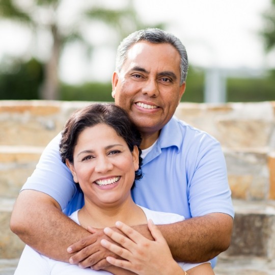 Older couple with healthy smiles after replacing missing teeth