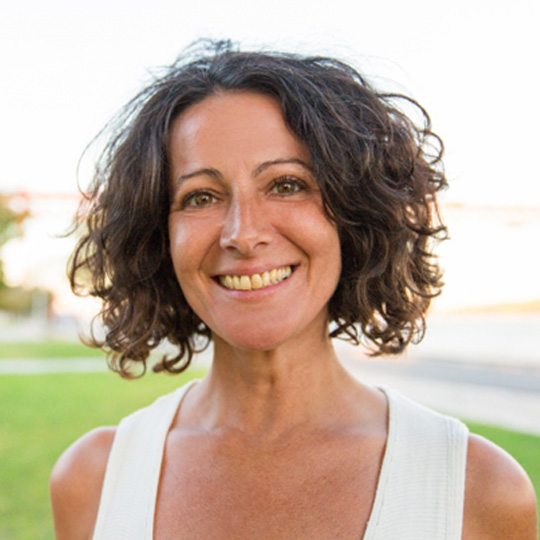woman in late 30s smiling outside