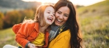 Mother holding child and sharing healthy smile after children's dentistry