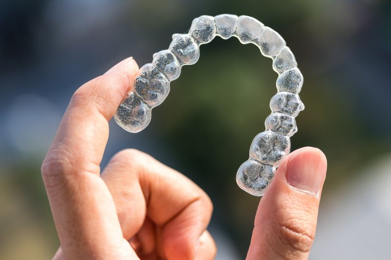 closeup of patient holding Invisalign aligner