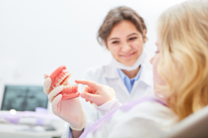 a young adult visiting their dentist to receive dentures 