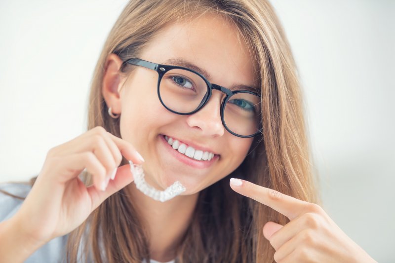 young woman with an Invisalign aligner