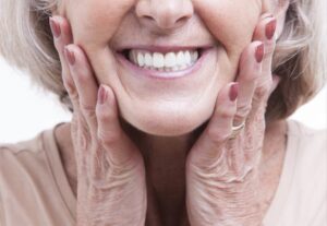 Senior woman showing off dentures.